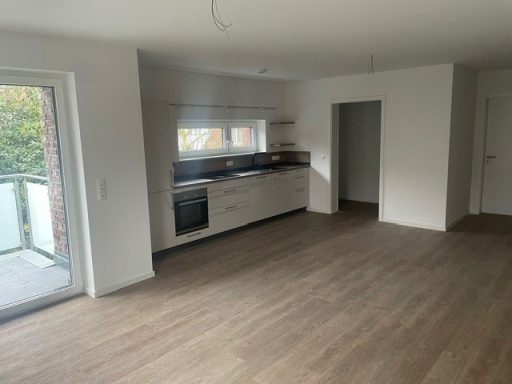 Helle, moderne Wohnküche mit Balkon und Holzboden.