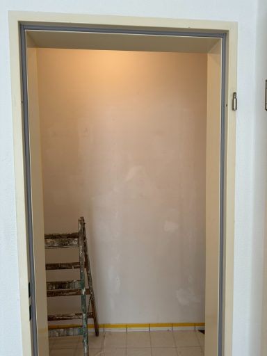 Ein unvollendeter Flur mit einer Leiter und einer glatten Wand.