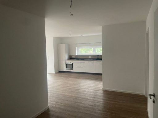 Heller Wohnraum mit offener Küche und Holzfußboden.